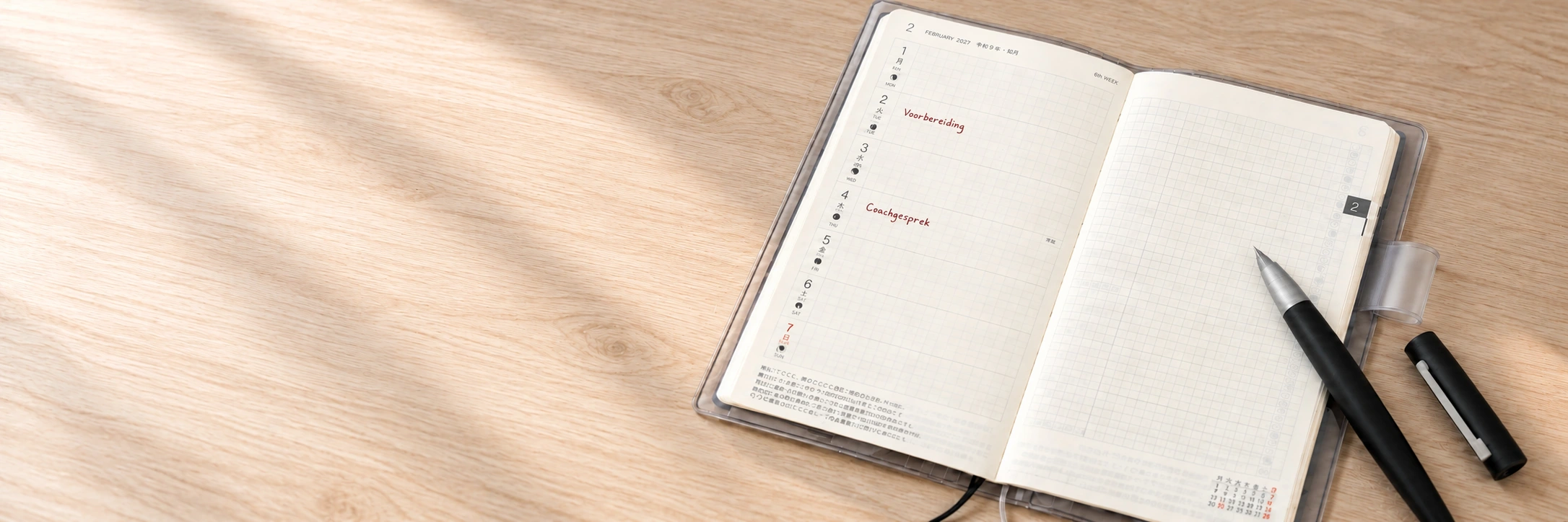 Open Hobonichi Weeks met rode notities en een zwarte LAMY 2000